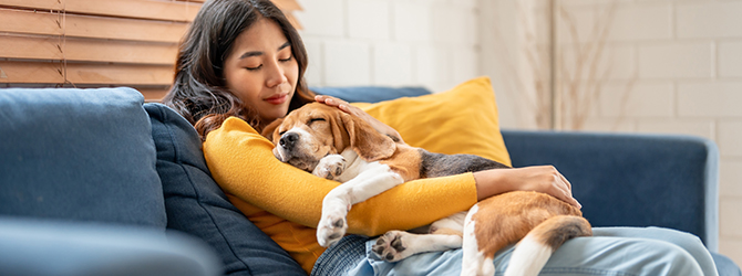 A photo of a woman holding her dog tightly for article on separation anxiety in dogs